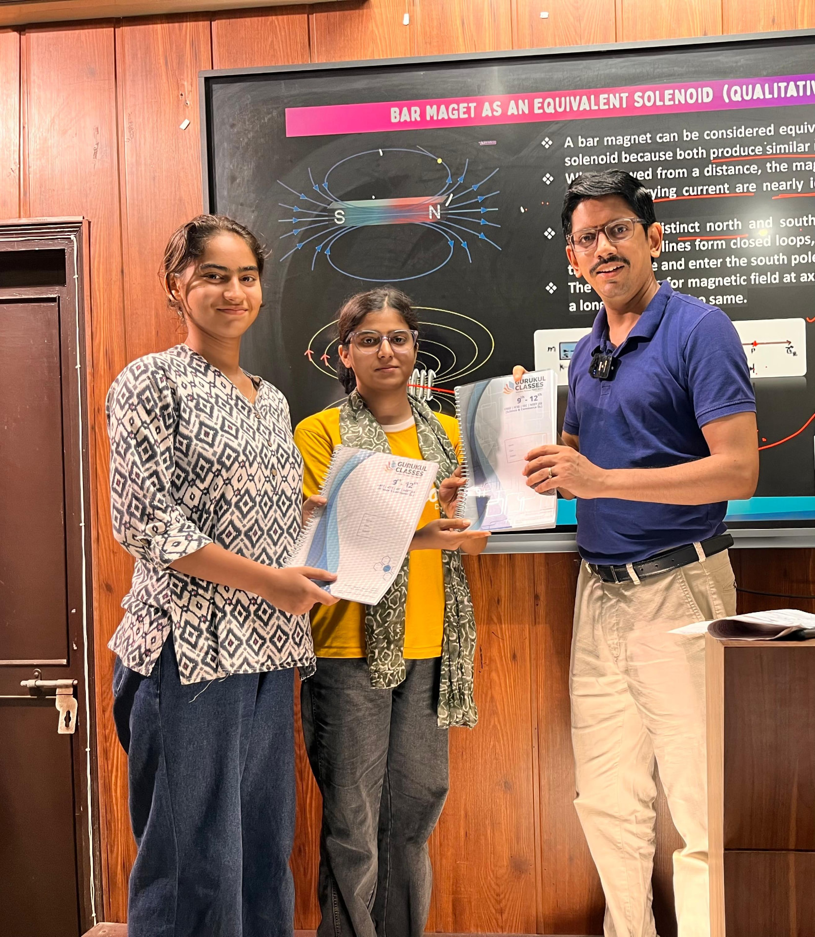 Vaibhav Agarwal handing Gurukul Classes notes to students during a magnetism lecture