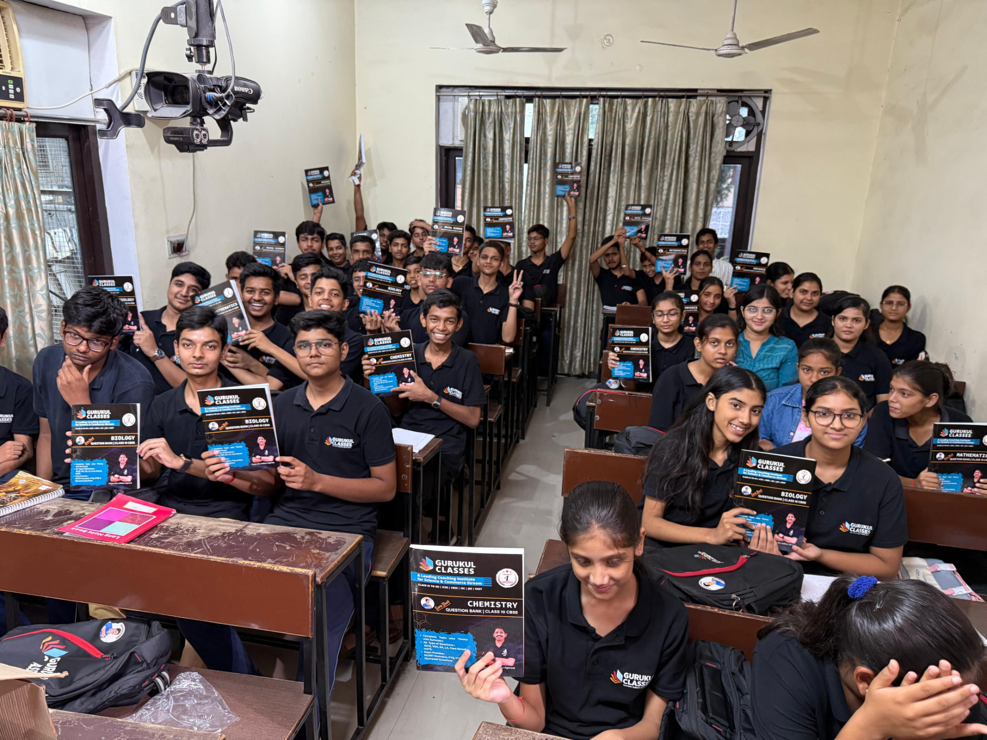 Students at Gurukul Classes holding their subject question banks