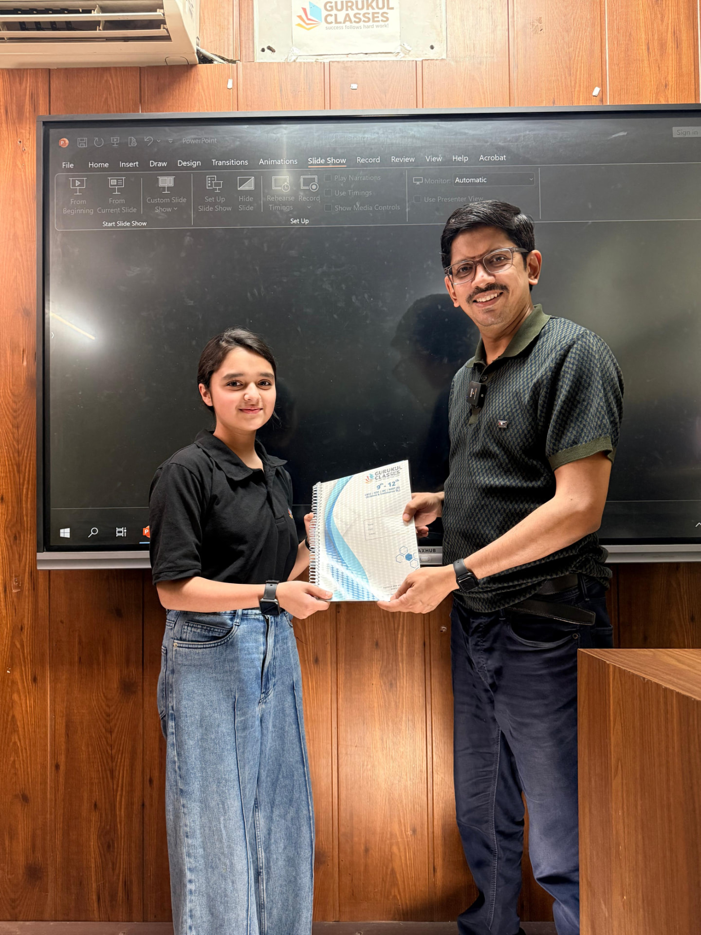 Student receiving Gurukul Classes study notes from faculty at the smart board