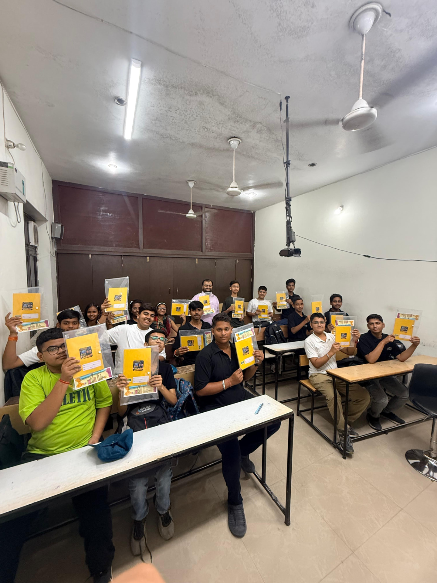 Gurukul Classes batch holding their study kits in the classroom